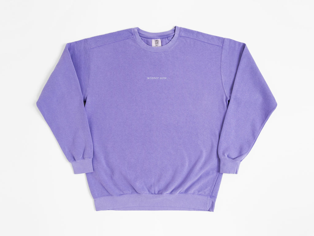 Purple sweatshirt with a small logo on a white background