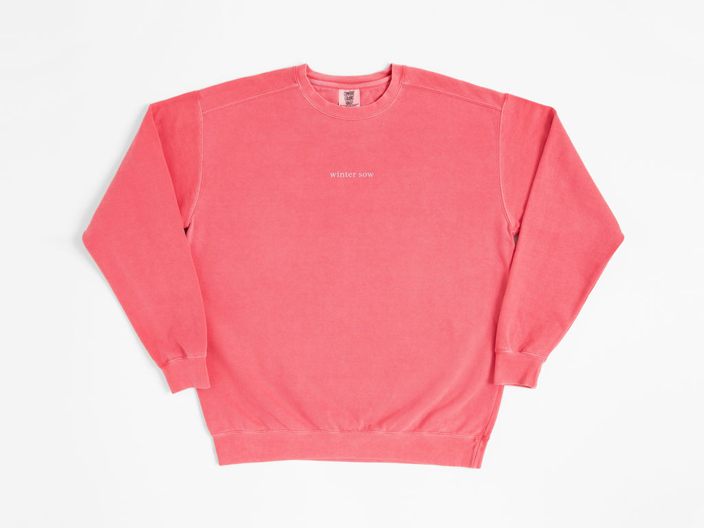 Pink sweatshirt with a small logo on a white background