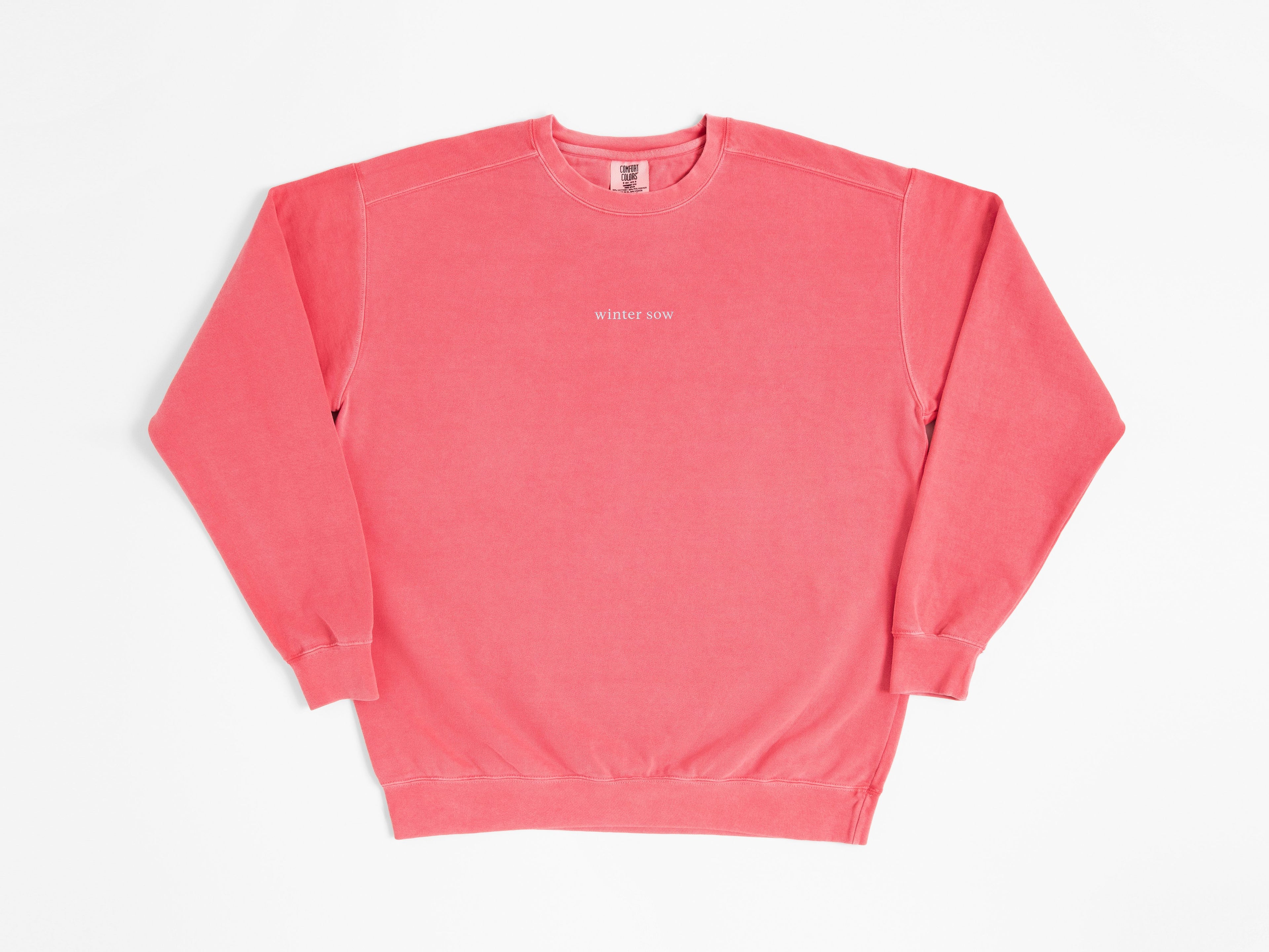 Pink sweatshirt with a small logo on a white background